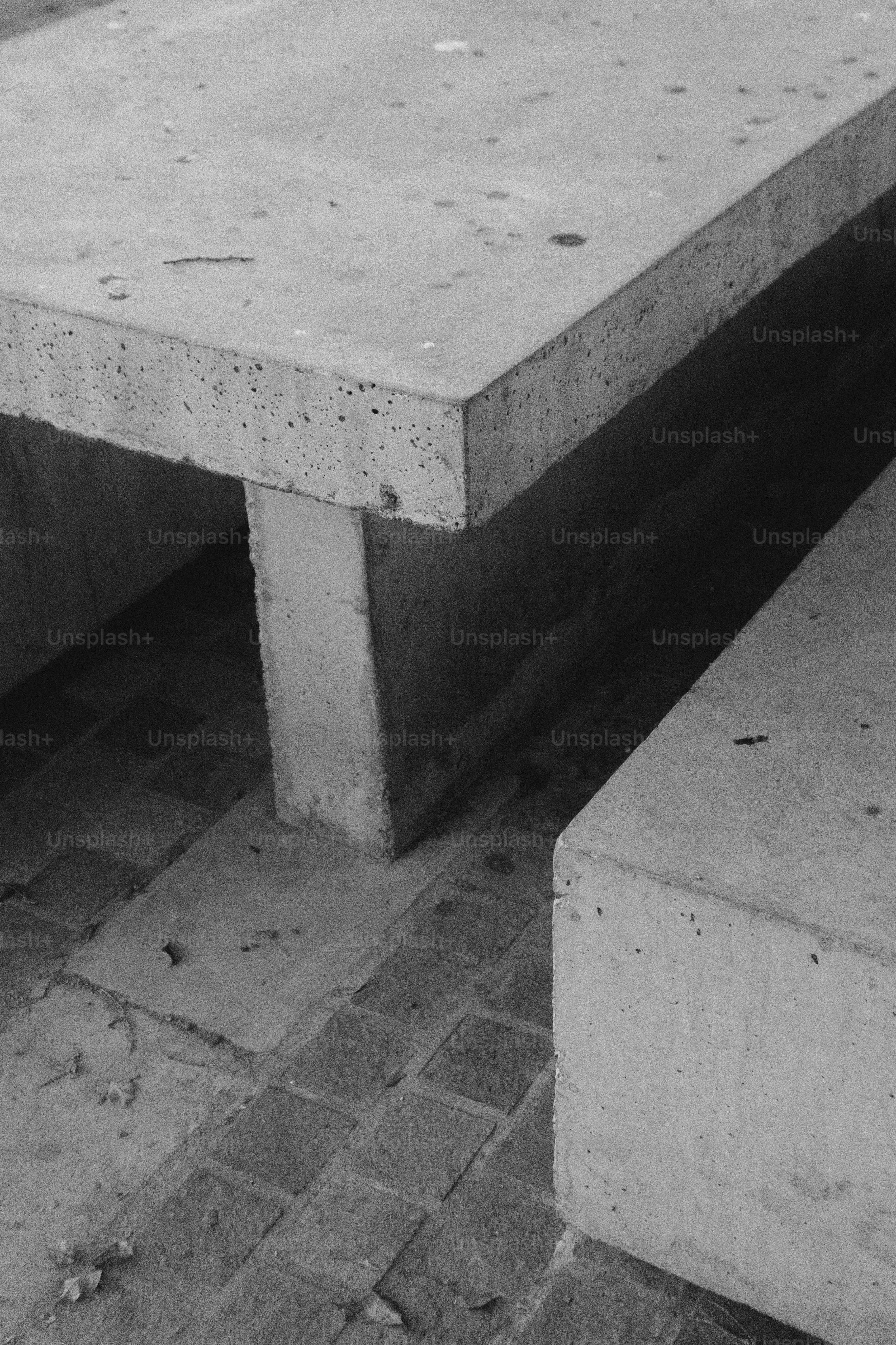 A black and white photo of a concrete bench
